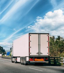Truck Or Traction Unit In Motion On Road, Freeway. Asphalt Motorway Highway Against Background Of Forest Landscape. Business Transportation And Trucking Industry.